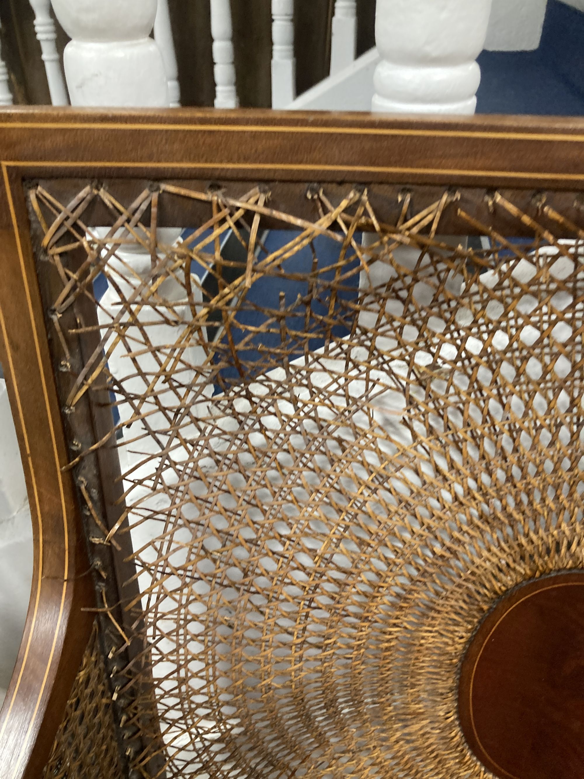 A Flemish carved oak dining chair and an Edwardian bergere chair